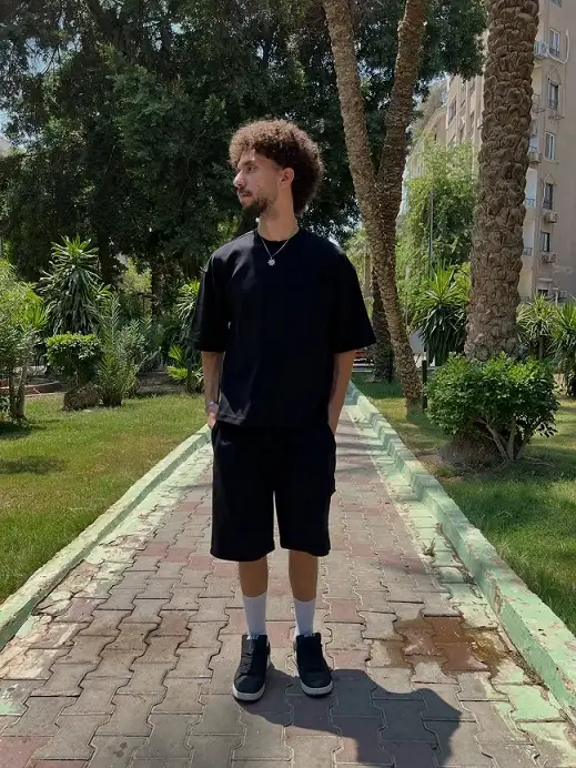 22 Black Shorts Outfit Ideas for Men That Actually Look Put Together 14 Black Tee and Knee Length Shorts in Full Daylight