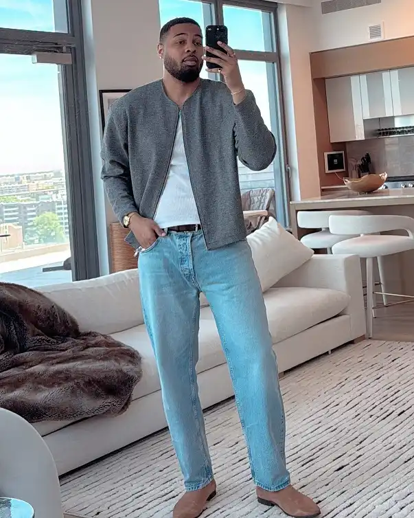Grey Zip Jacket Over a White Tank With Faded Blue Jeans