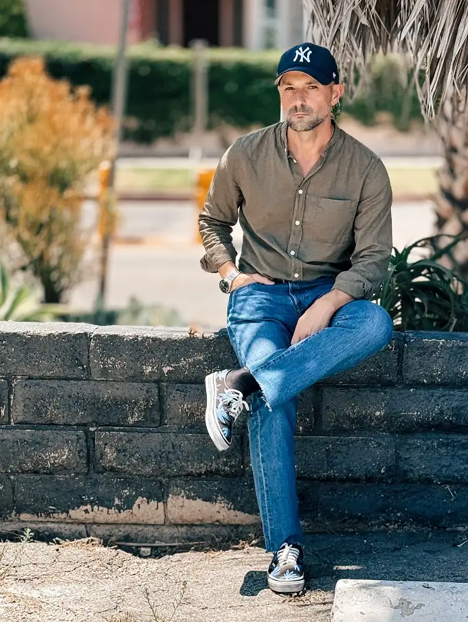 27 Minimalist Jeans and Pants for Men That Work in Every Season 3 Mid Blue Jeans and an Olive Shirt for Guys Past 35