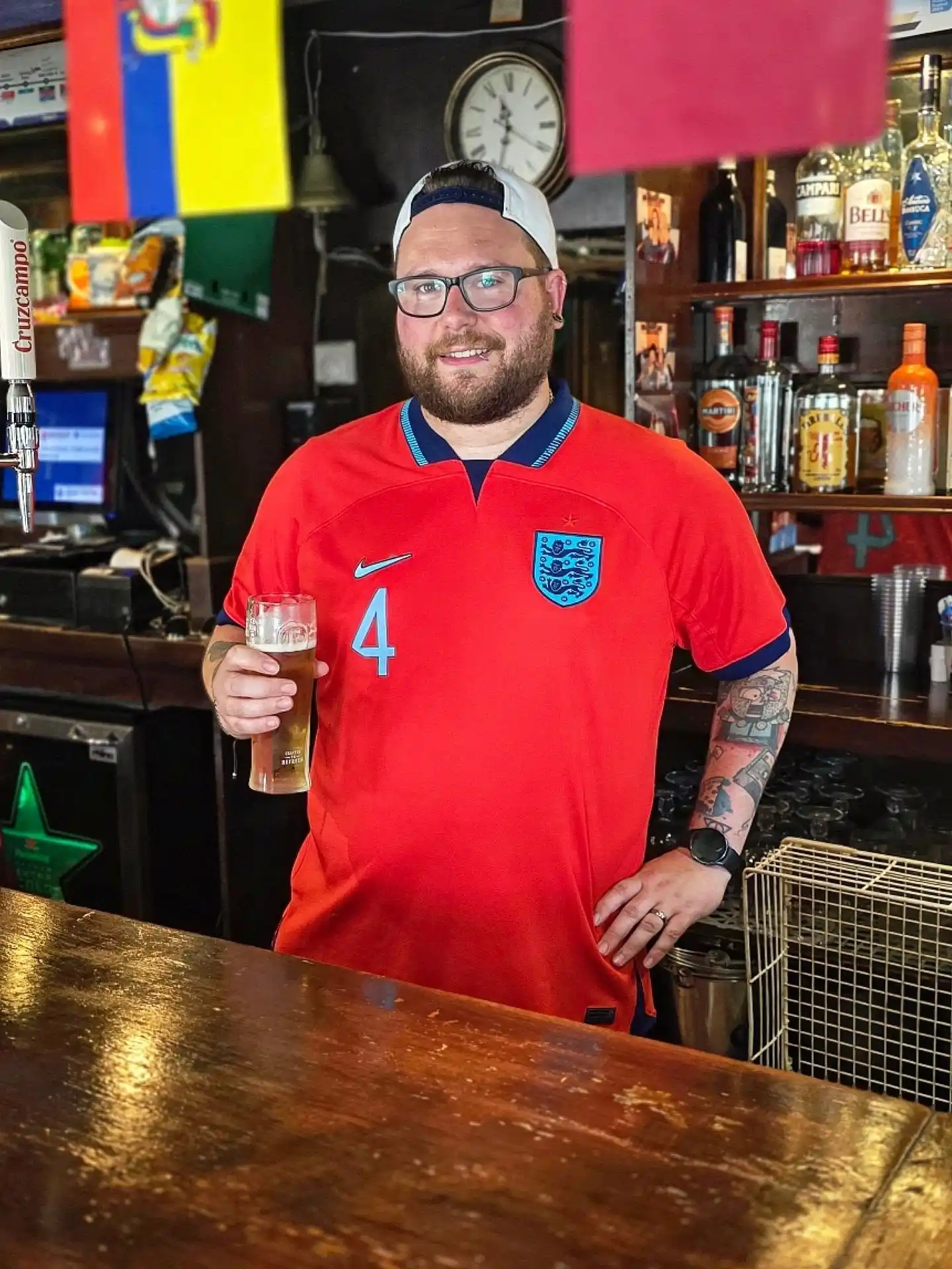 14. England Away Red Jersey With a White Cap and Glasses at the Pub