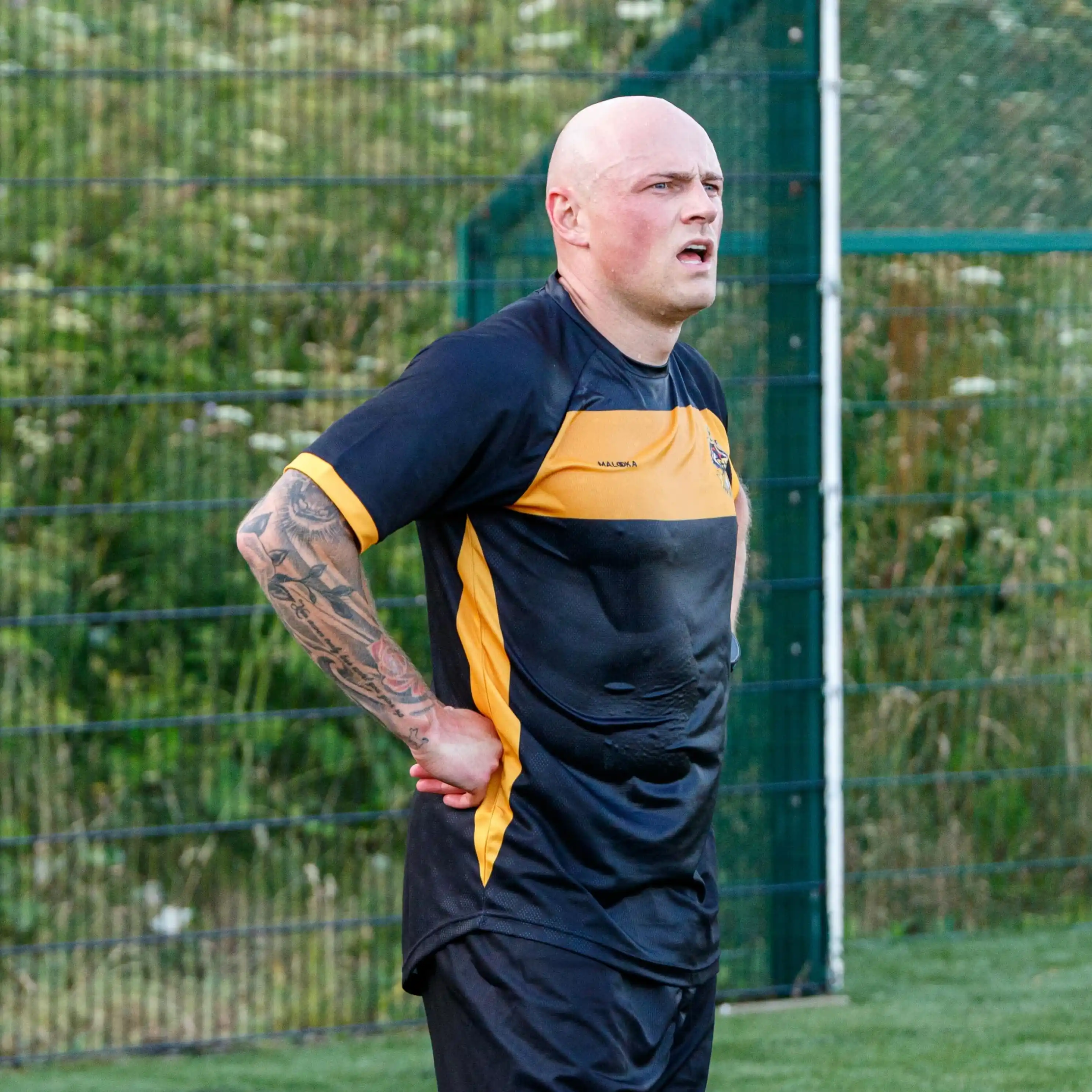 5. Black And Amber Soccer Jersey With Black Shorts On The Pitch