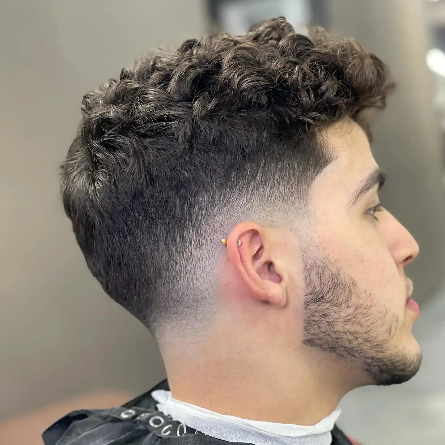 9. Salt and Pepper Curls with Low Skin Fade