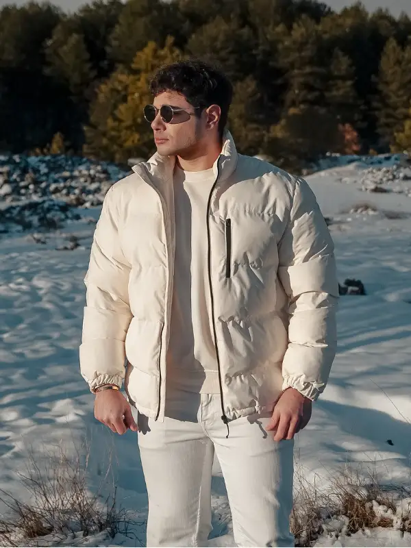 25 Stylish Winter Travel Outfits for Men & Ski Trips 18 Full Cream Puffer and White Jeans for a Head Turning Winter Look