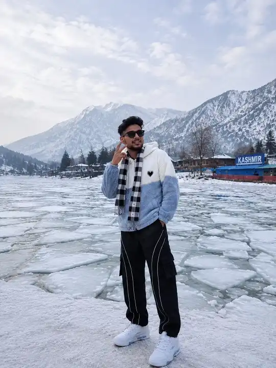 25 Stylish Winter Travel Outfits for Men & Ski Trips 12 Color Block Sherpa Hoodie With Black Cargos for Lakeside Days