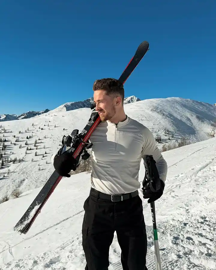 25 Stylish Winter Travel Outfits for Men & Ski Trips 26 Cream Half Zip Base Layer With Black Ski Pants for Bluebird Days