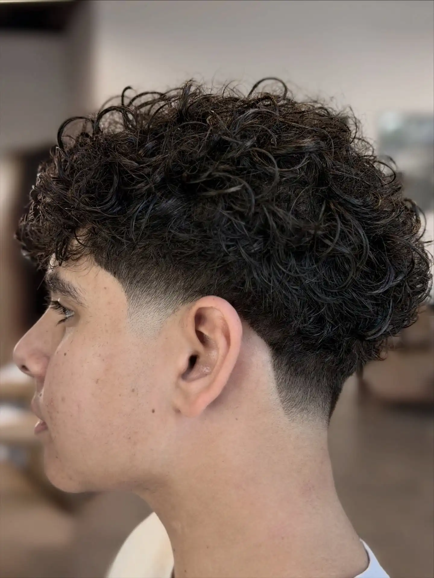 2. Volume Top Curls with Skin Fade
