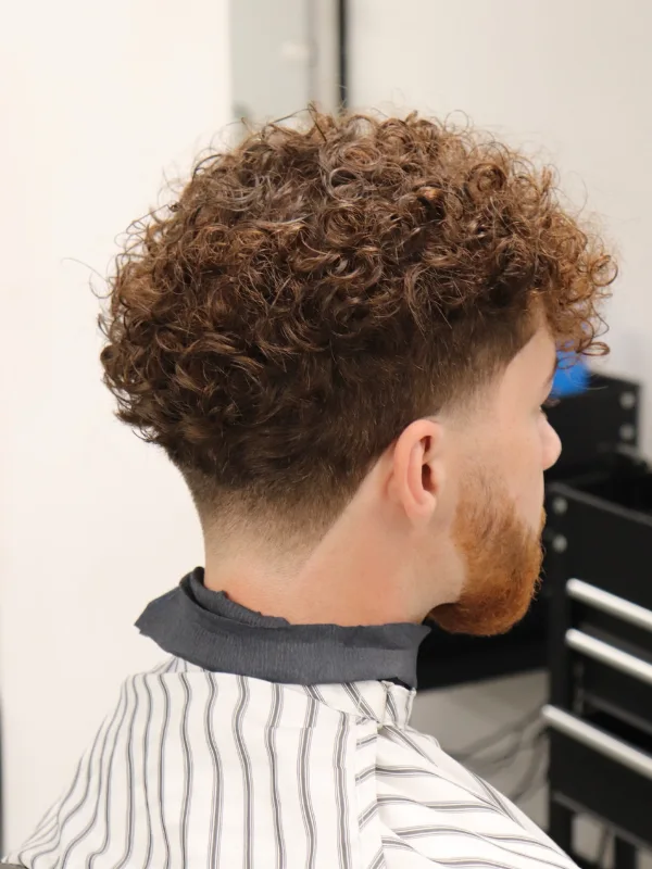 Short Curly Hair for Men: 23 Low-Effort Styles 19 Copper Curl Volume Over a V-Shaped Neckline Fade
