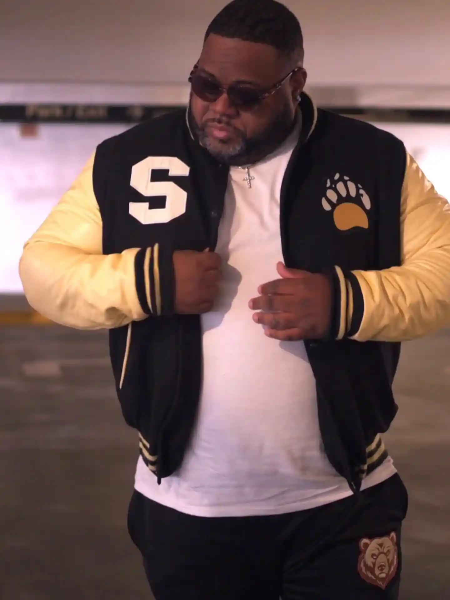 15 Effortless Outfit Ideas for Plus Size Men Real Men Swear By 12 11. Black and Cream Varsity Jacket over a White Tee with Matching Track Pants