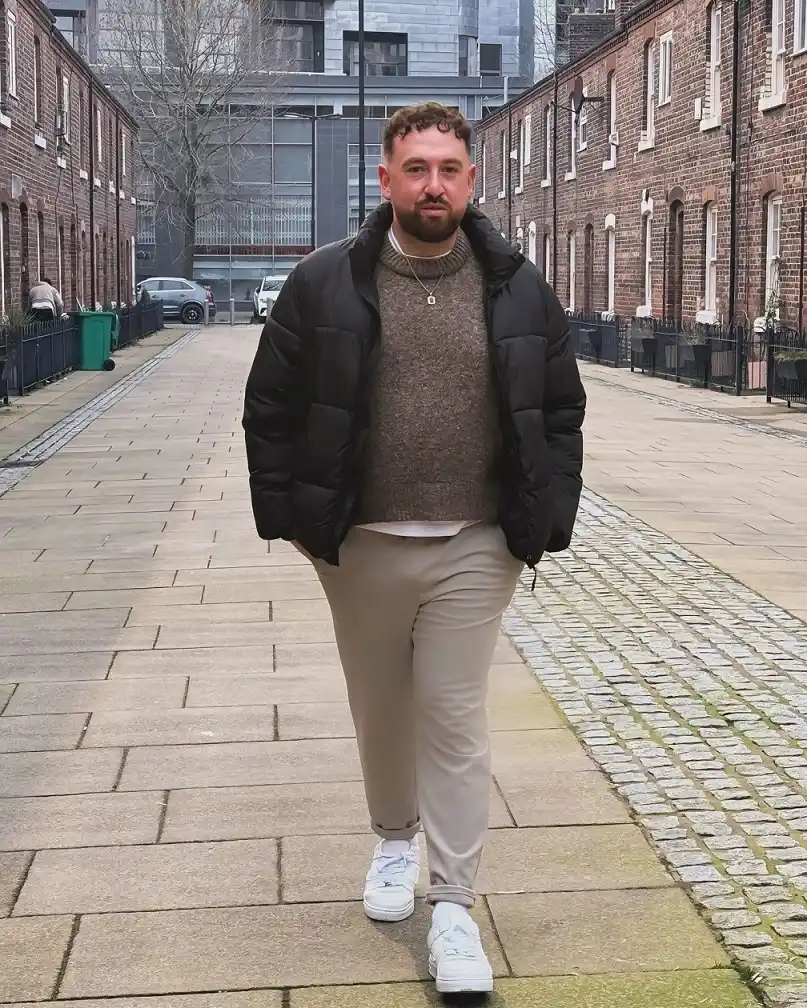 15 Effortless Outfit Ideas for Plus Size Men Real Men Swear By 5 4. Black Puffer Over a Marl Knit with Cuffed Stone Trousers for Cold Days