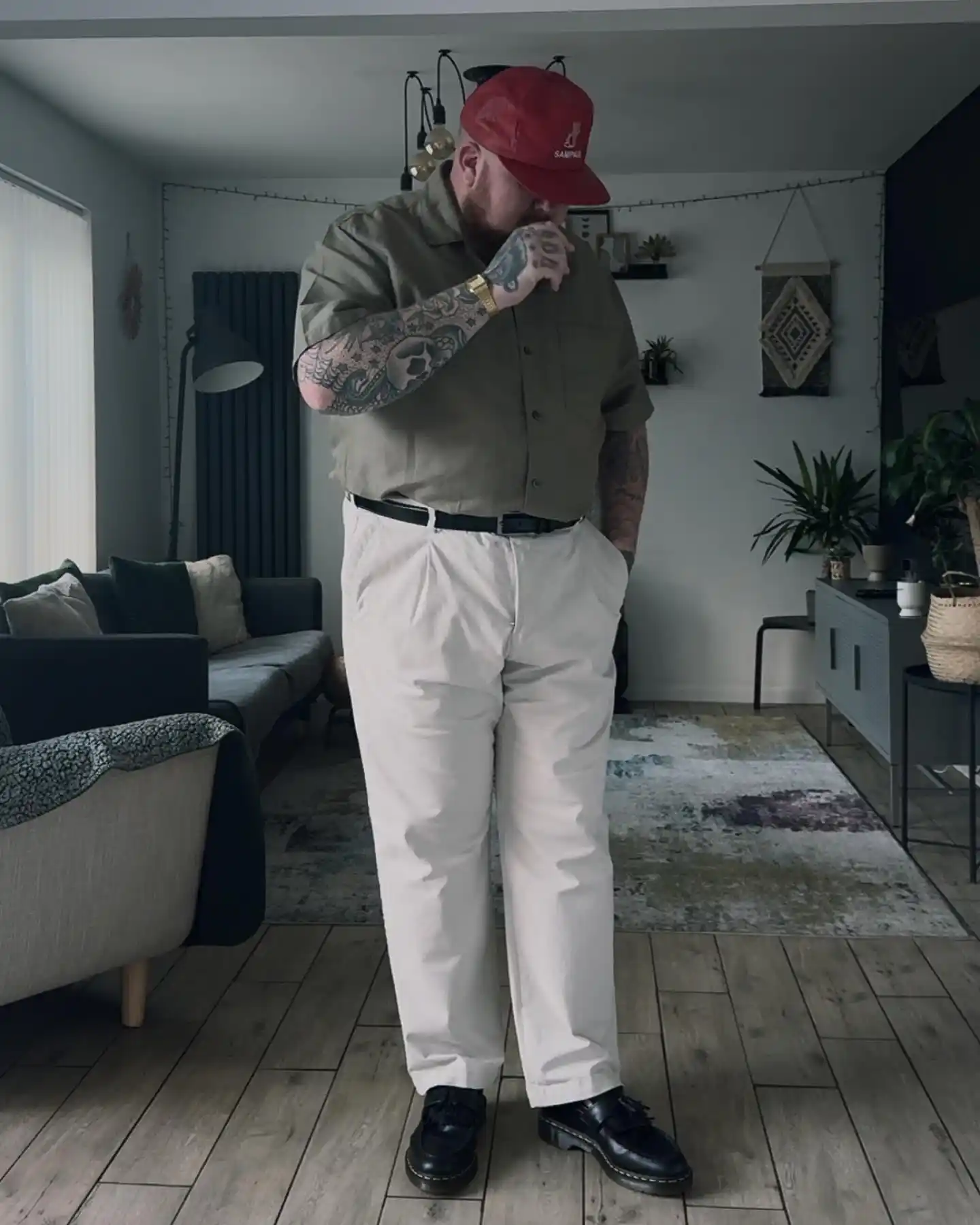 15 Effortless Outfit Ideas for Plus Size Men Real Men Swear By 4 3. Olive Camp Shirt and Cream Pleated Pants with a Red Cap